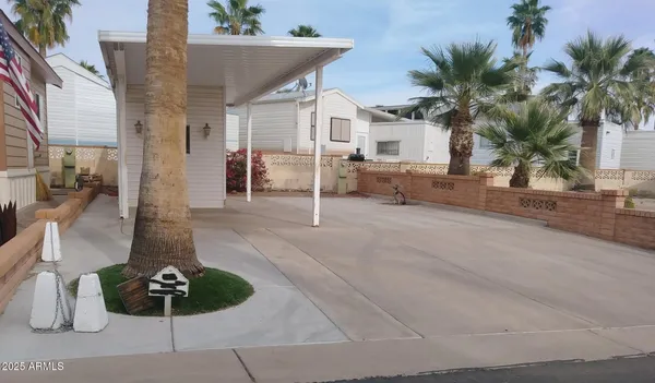 a backyard of a house with potted plants and palm tree