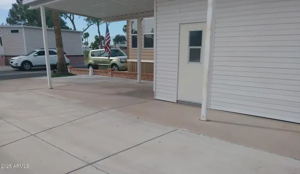 a view of a patio with table and chairs and a barbeque