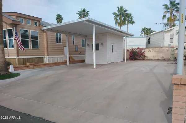 a view of a house with a patio and a yard