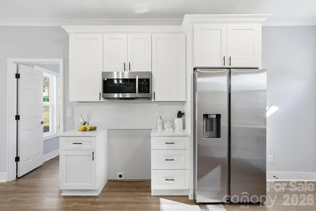 a kitchen with granite countertop white cabinets and a window