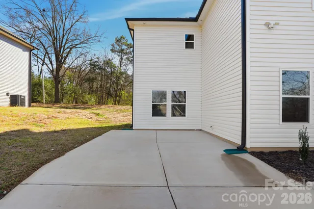 a view of a house with backyard and trees