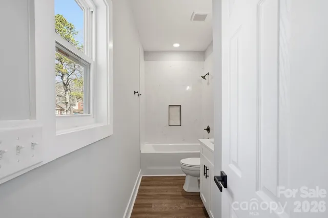 a bathroom with a granite countertop sink a toilet and bathtub