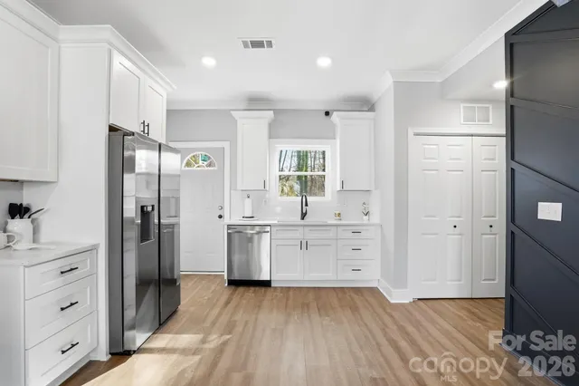a kitchen with white cabinets and stainless steel appliances
