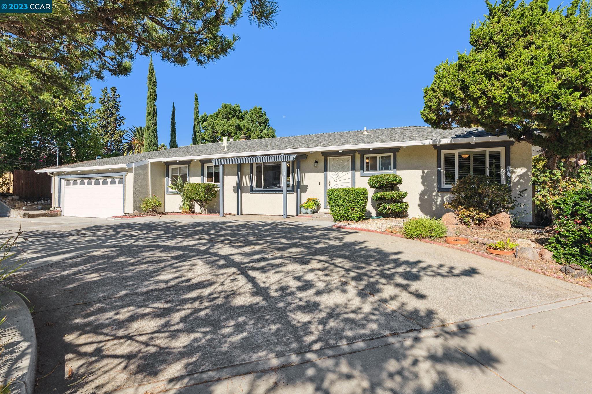 a front view of a house with a yard and potted plants