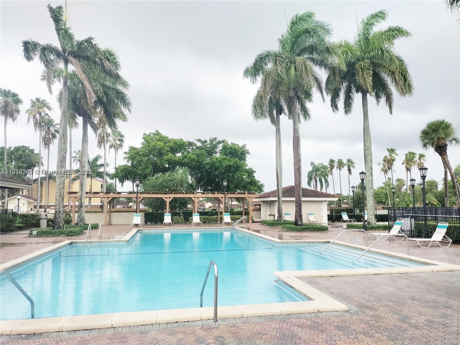 18240 Mediterranean Boulevard, Unit 411 Hialeah, FL 33015 - Photo 2 of 2 a view of swimming pool with outdoor seating and palm tree