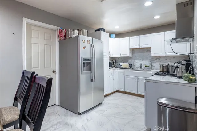 a kitchen with stainless steel appliances a refrigerator sink and cabinets