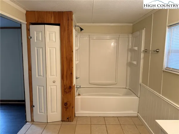 a bathroom with a tub shower and a sink