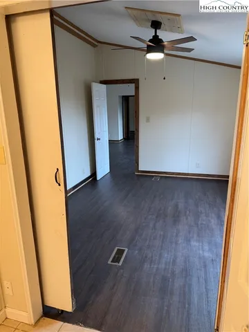 a view of a hallway with wooden floor and door