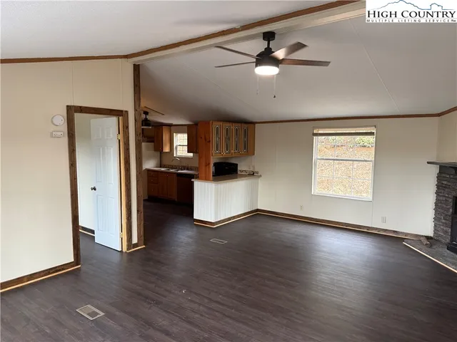 a view of a kitchen with a sink cabinet a ceiling fan and wooden floor