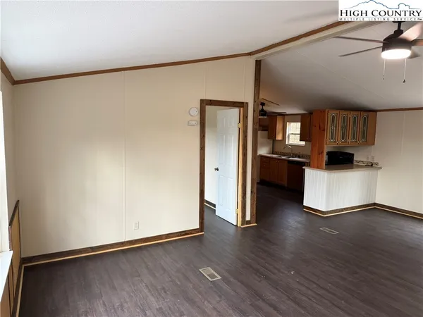 a view of kitchen with stainless steel appliances wooden floor and a refrigerator