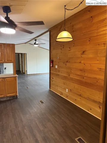 a view of a room with wooden floor and a ceiling fan