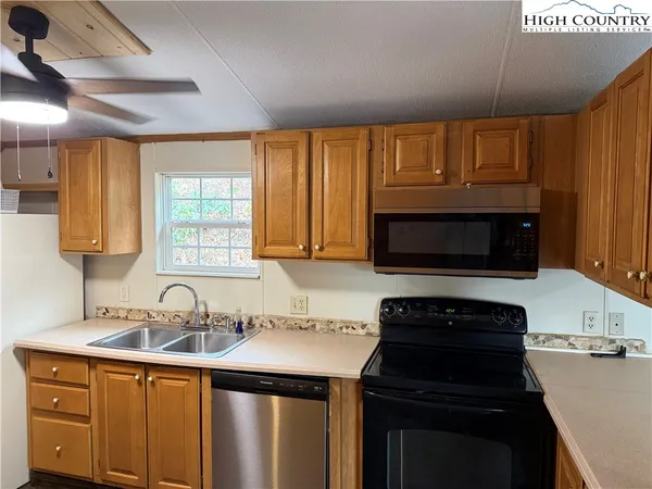 a kitchen with granite countertop a sink stainless steel appliances and cabinets