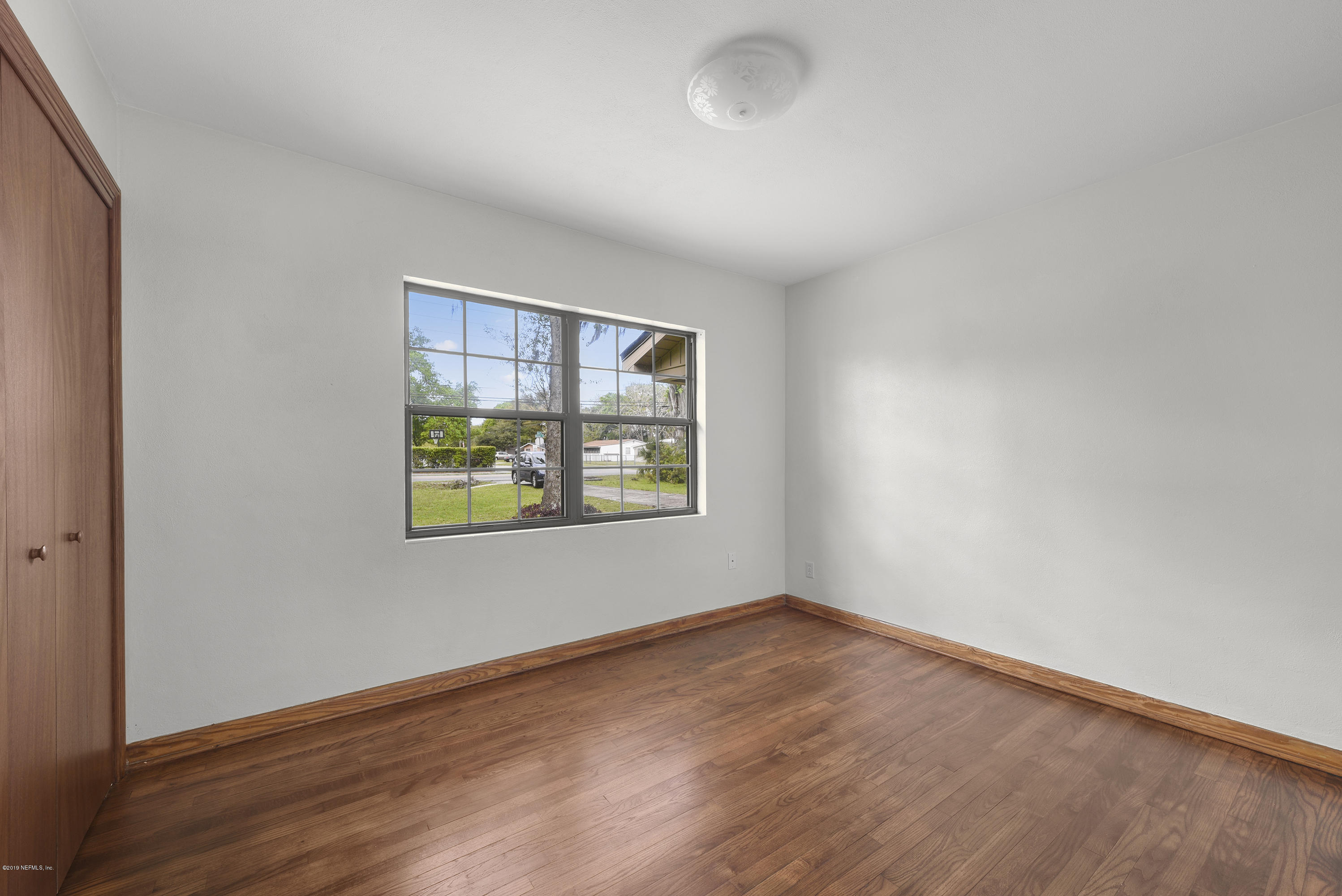 5621 Ricker Road Jacksonville, FL 32244 - Photo 12 of 22 an empty room with a window and wooden floor