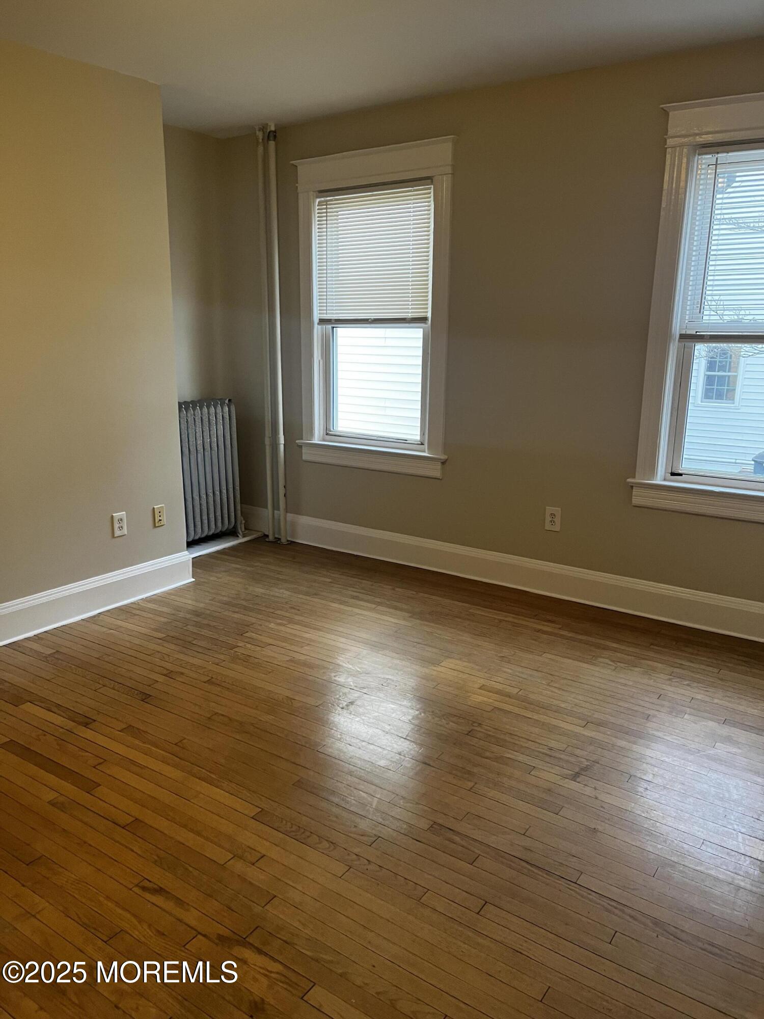 103 Main Street, Unit 1 Matawan, NJ 07747 - Photo 4 of 12 a view of an empty room with wooden floor and a window