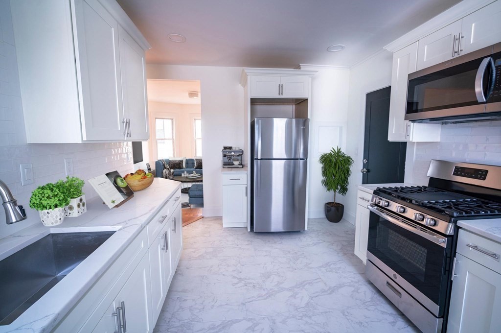 302 Summit Avenue, Unit 1 Boston, MA 02135 - Photo 2 of 13 a kitchen with stainless steel appliances a stove a sink a refrigerator a stove a microwave a sink and cabinets
