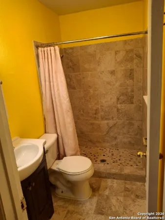 a bathroom with a toilet and a shower