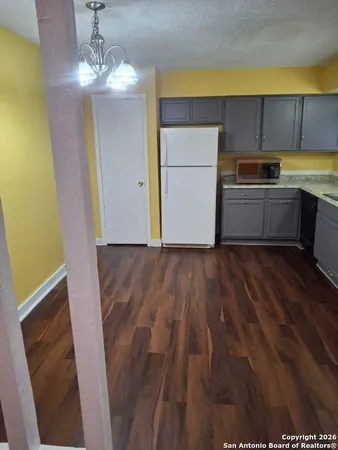 a kitchen with wooden floor and a refrigerator
