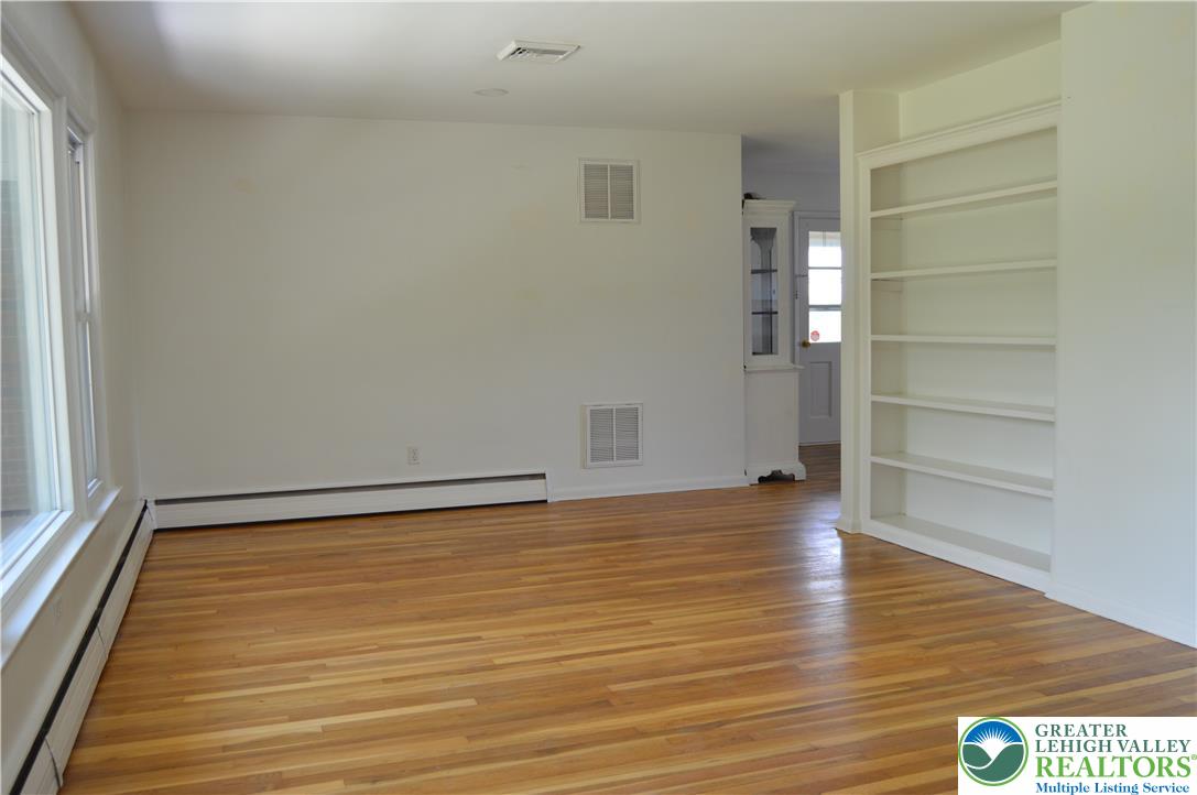 1819 Blue Barn Road Orefield, PA 18069 - Photo 9 of 21 Sun-filled living area featuring rich hardwood flooring and built-in shelving for curated displays.