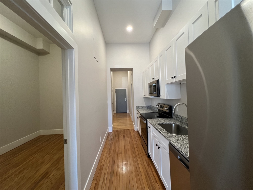 34 St Joseph Street, Unit 23 Fall River, MA 02723 - Photo 13 of 19 a large kitchen with a sink and wooden floor