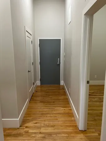 a view of a hallway with wooden floor and staircase