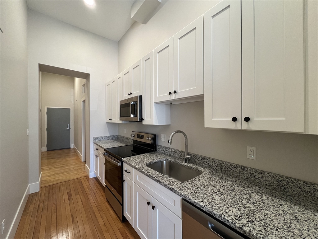 34 St Joseph Street, Unit 23 Fall River, MA 02723 - Photo 3 of 19 a kitchen with granite countertop a sink a stove and cabinets
