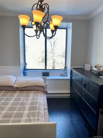 a bedroom with a bed lamp and a large window