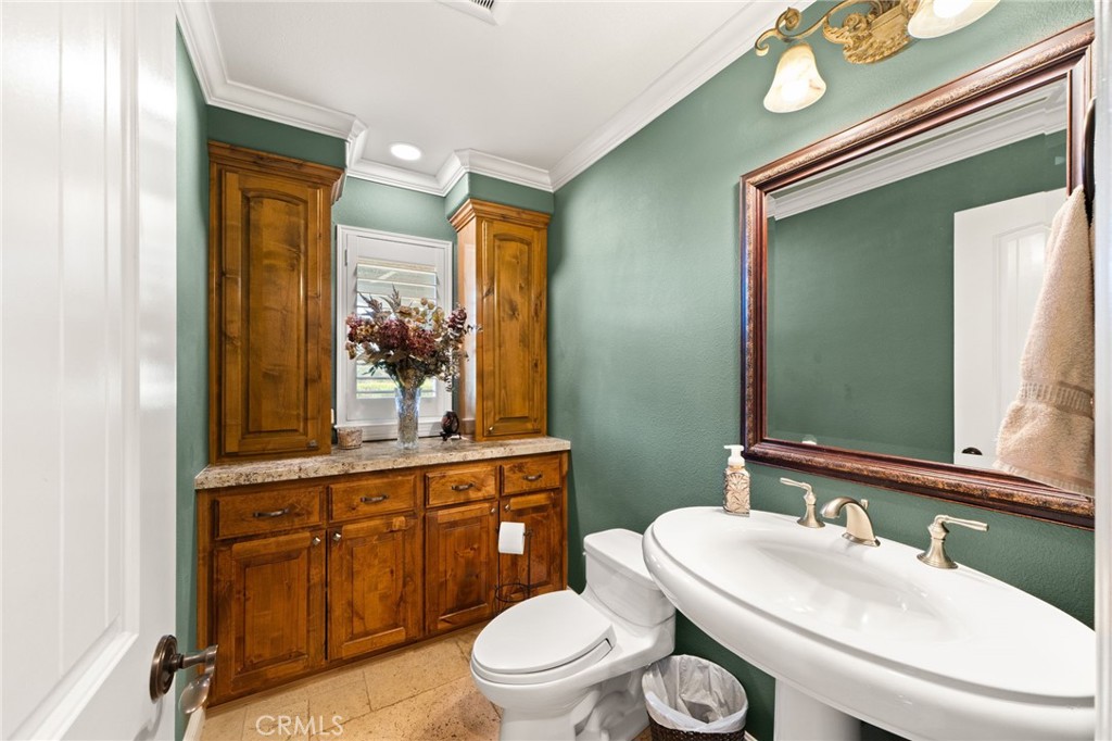 38136 Butterfly Court Yucaipa, CA 92399 - Photo 43 of 71 a bathroom with a toilet a sink and mirror