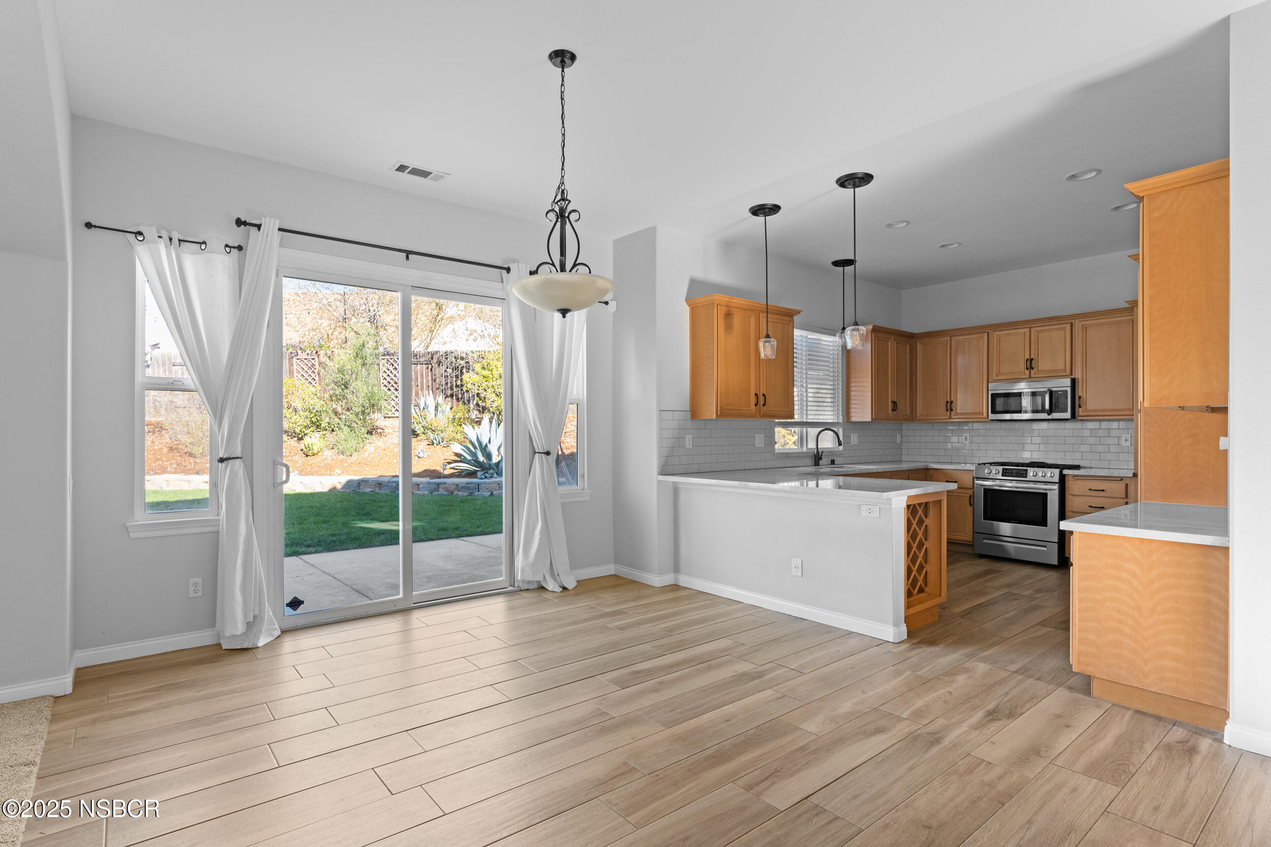 608 Celestial Way Lompoc, CA 93436 - Photo 5 of 40 a open kitchen with stainless steel appliances granite countertop a refrigerator a sink dishwasher a stove and white countertops with wooden floor