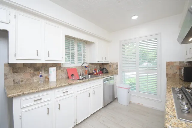 a kitchen with a sink a stove and cabinets
