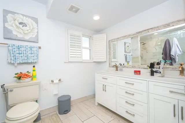 a bathroom with a sink a toilet and a mirror