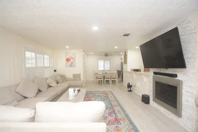a view of a backyard with large trees and wooden fence