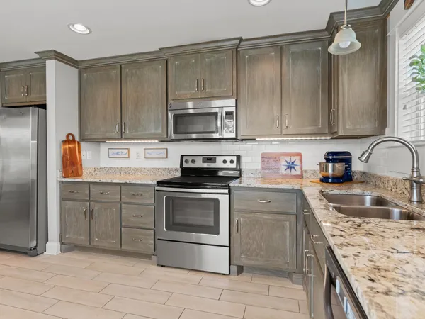 a kitchen with granite countertop a sink stainless steel appliances and cabinets
