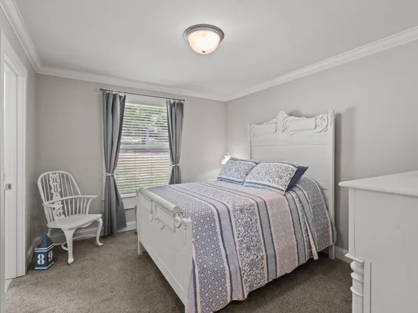 a bedroom with a bed chair and a window