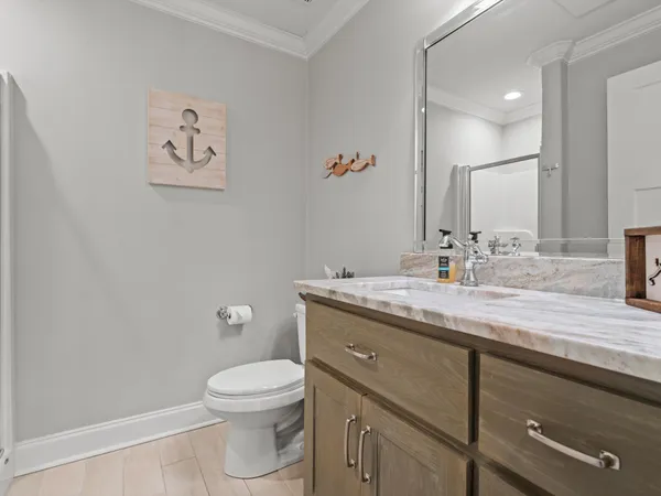 a bathroom with a granite countertop toilet sink and a mirror