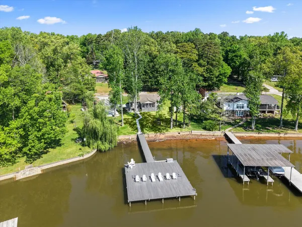 a view of a swimming pool and lounge chairs in back yard