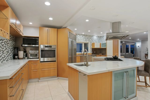 a kitchen with stainless steel appliances granite countertop a sink and a refrigerator