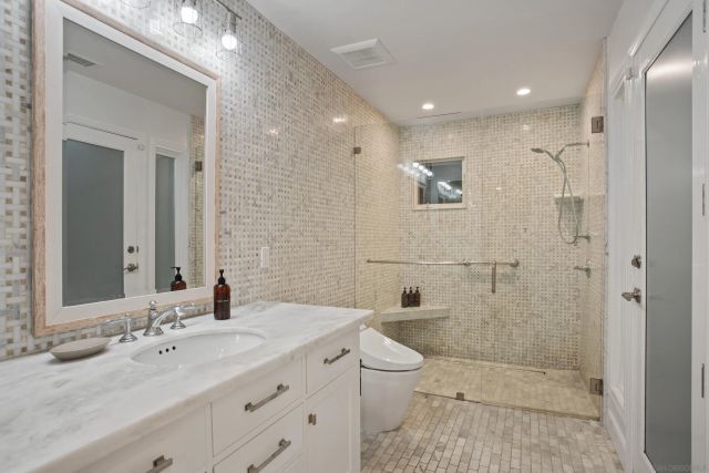 a bathroom with a double vanity sink toilet and shower
