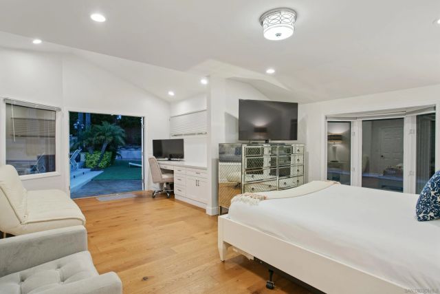 a large bedroom with a large bed and a flat screen tv