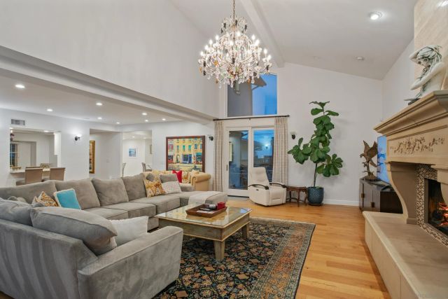 a living room with furniture a chandelier and a fireplace