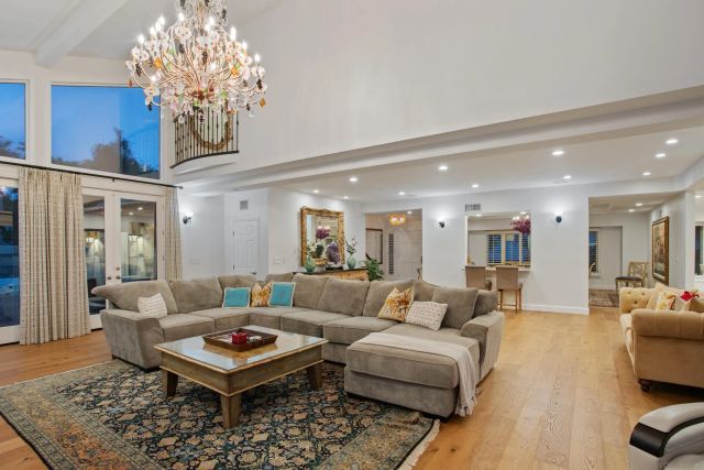 a living room with furniture a chandelier and a rug