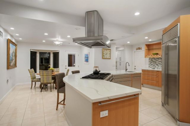 a kitchen with stainless steel appliances kitchen island granite countertop a sink and cabinets