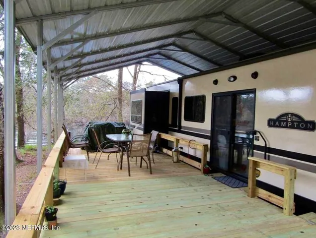 a view of a porch with furniture and a grill