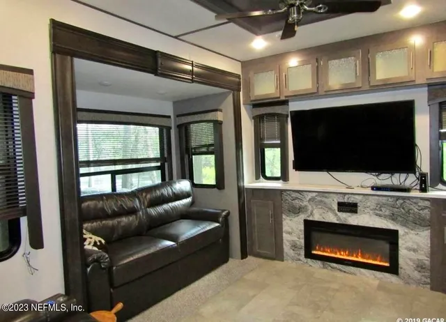a living room with furniture a flat screen tv and a fireplace