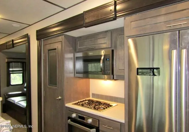 a kitchen with a refrigerator and a stove