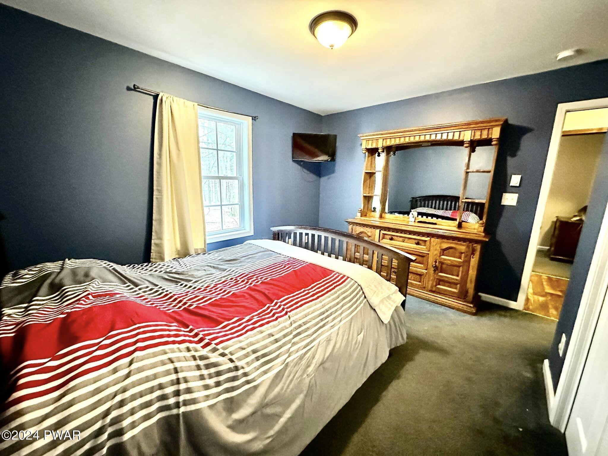 210 Fox Road Dingmans Ferry, PA 18328 - Photo 27 of 38 a bedroom with a bed and a flat screen tv