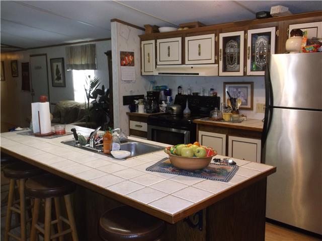 127 Sparrow Road Lafayette, TN 37083 - Photo 2 of 12 Spacious kitchen with large working island. Seller has purchased another home and will be taking these appliances and replacing them with white ones.