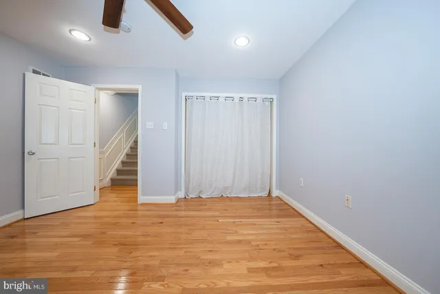 an empty room with wooden floor and entryway