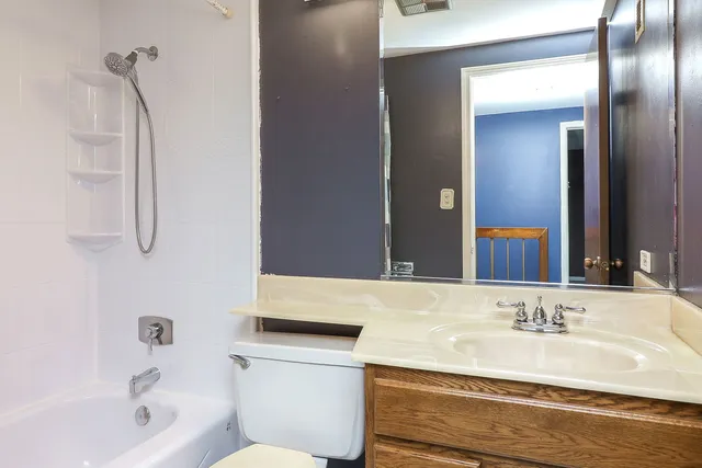 a bathroom with a granite countertop sink a toilet and bathtub