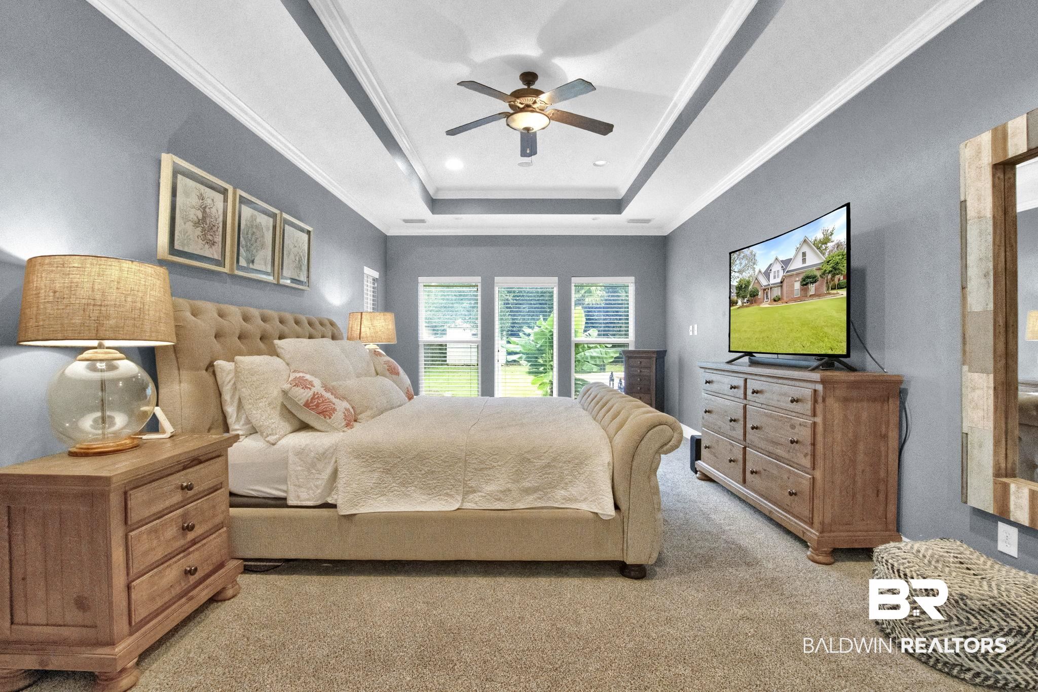 9002 Parliament Circle Daphne, AL 36526 - Photo 32 of 73 New carpeted bedroom with a tray ceiling, ceiling fan, and crown molding