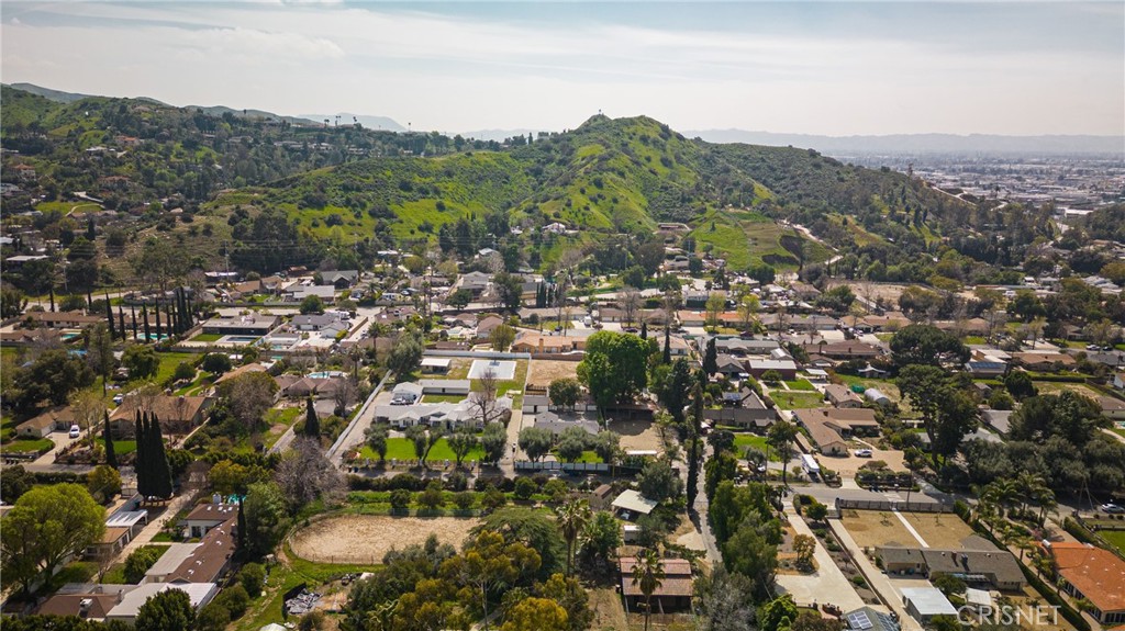 an aerial view of residential houses with outdoor space and trees